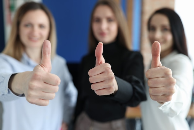 Três mulheres de negócios mostrando um gesto de polegar