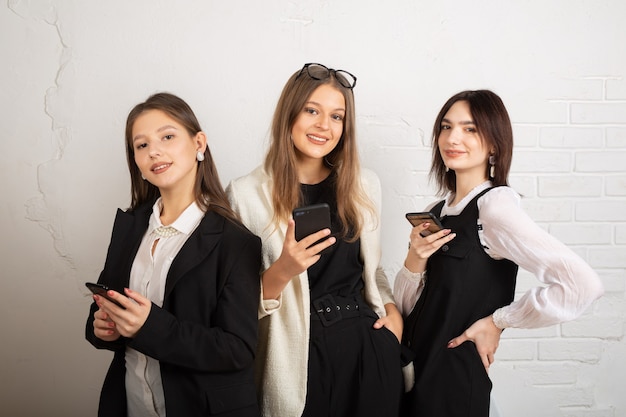 três mulheres jovens com telefones celulares