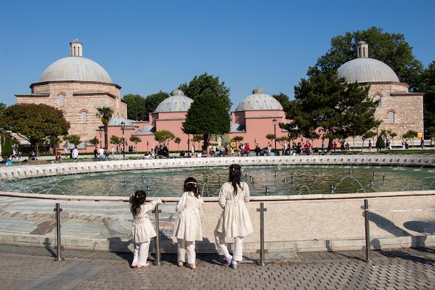 Tres niñas junto a la piscina con cúpulas a la vista