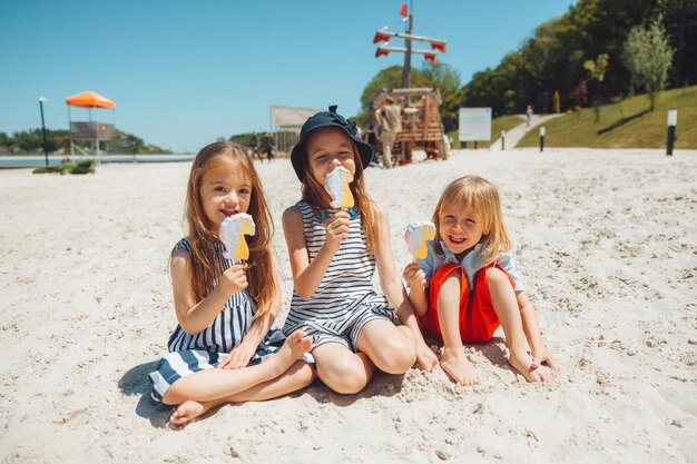 Tres niños comen helado en la playa un niño con síndrome de down lleva una vida normal