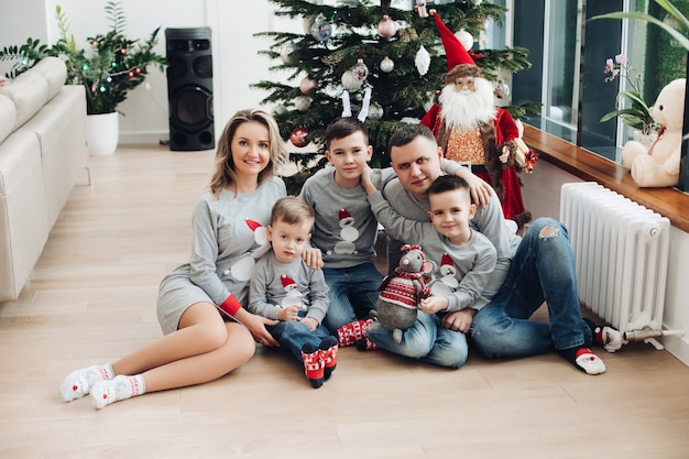 Tres niños con los mismos jerseys mientras posan ante la cámara con sus padres. Concepto de vacaciones