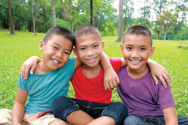 Foto tres niños sonriendo y abrazándose