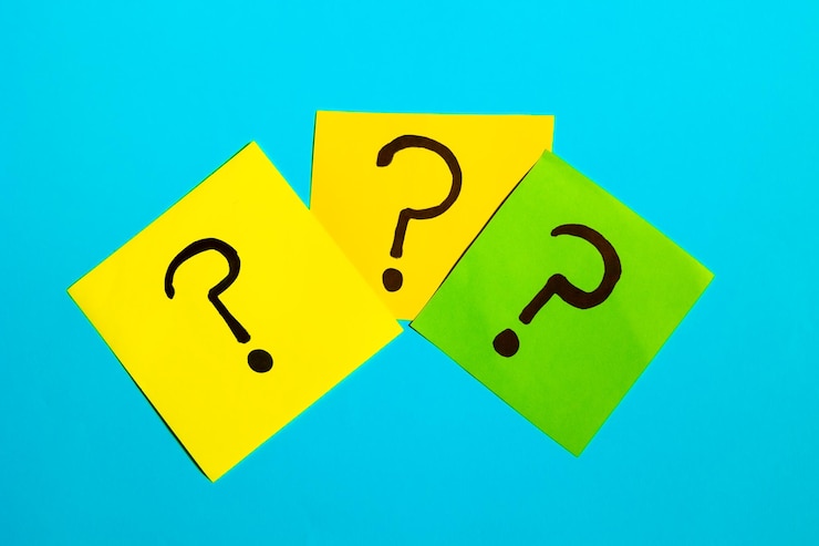 Foto tres notas adhesivas con signos de interrogación en un fondo azul