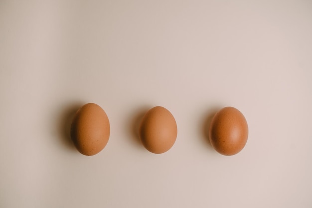 três ovos de galinha em um fundo branco