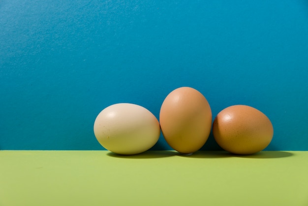 Foto três ovos em fundo verde e azul