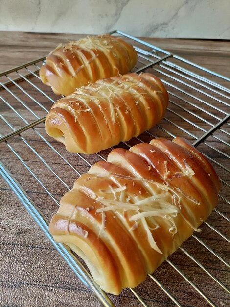 Tres panes sobre una rejilla con queso encima.