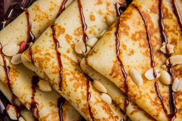 Tres panqueques en un plato con salsa de chocolate