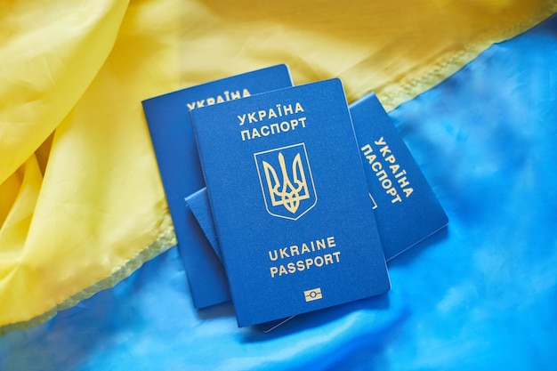 Tres pasaportes biométricos ucranianos en la bandera de inmigración de Ucrania porque la guerra