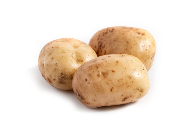 Tres patatas blancas frescas sobre un fondo blanco.