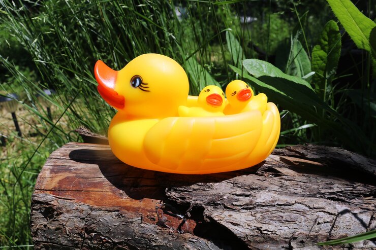 Foto três patos de borracha amarelos para nadar família de patos de borracha amarelos em uma superfície de madeira