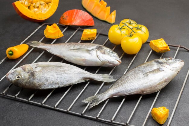 Foto tres peces dorado crudos a la parrilla