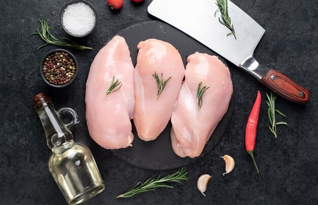 Tres pechugas de pollo crudas sobre fondo de piedra