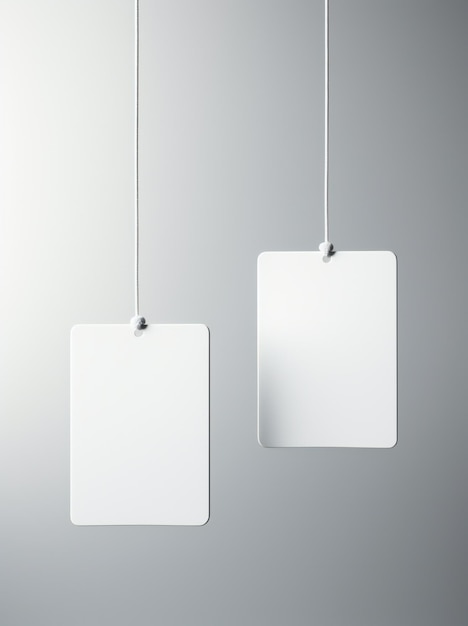 Três pedaços de papel branco pendurados numa parede cinzenta.