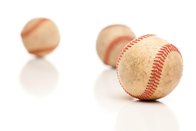 Tres pelotas de béisbol aisladas en blanco reflectante