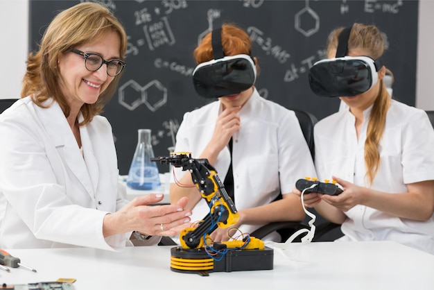 Tres personas con batas de laboratorio miran un robot con gafas vr.