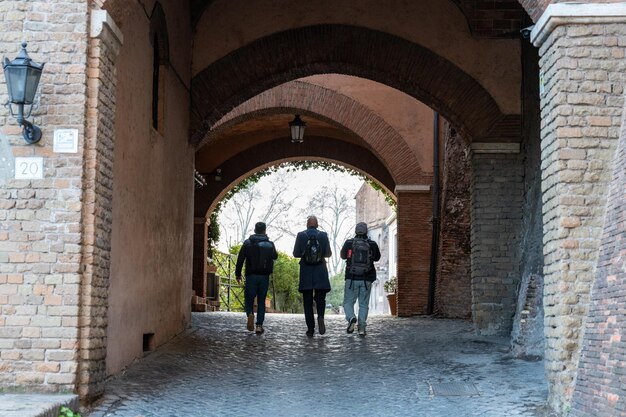 Tres personas caminando por un callejón estrecho