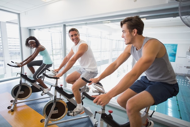 Tres personas en forma trabajando en bicicletas de ejercicio