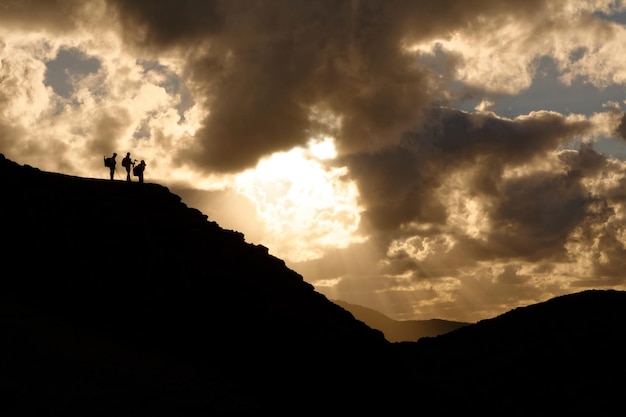 Tres personas en rocas de silueta