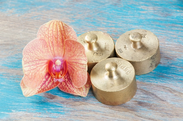 Três pesos de bronze antigos para escalas em fundo azul de madeira. copie o espaço para adereços de fotografia de texto e comida.