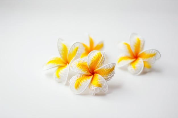 Tres pétalos de flores blancas con centros amarillos están sobre una superficie blanca.