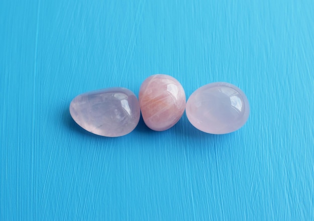 Tres piedras de cuarzo rosa caídas Los cristales semipreciosos de cuarzo rosa son un talismán de amor para las mujeres.