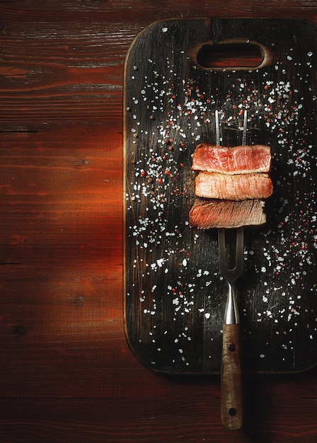 Tres piezas de carne en un tenedor para carne tres tipos de carne asada rara mediobien hecho