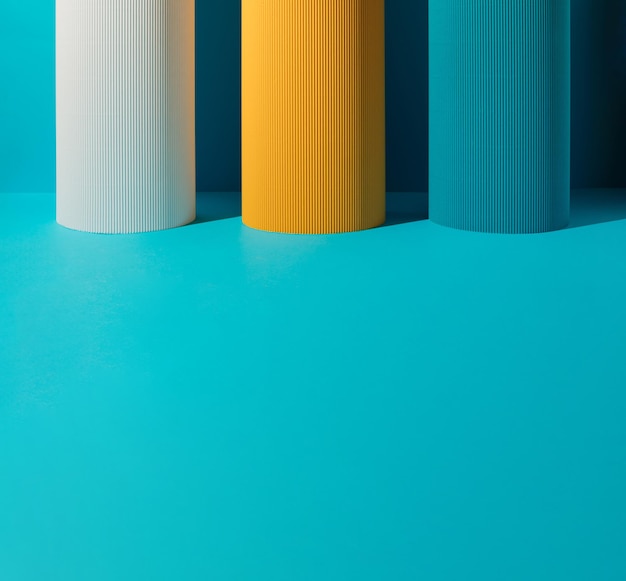 Tres pilares de papel blanco amarillo y azul sobre fondo azul con espacio de copia