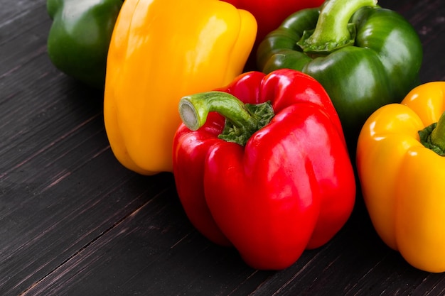 Tres pimientos dulces sobre un fondo de madera Cocinar ensalada de verduras