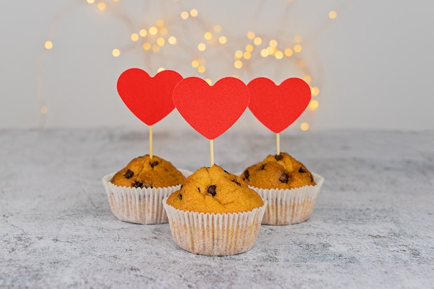 Tres sabrosos cupcakes con grandes corazones rojos