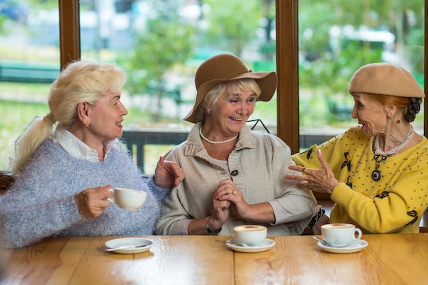 Foto três senhoras idosas tomando café