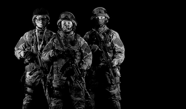 Tres soldados de uniforme con un arma en la mano miran amenazadoramente. Técnica mixta