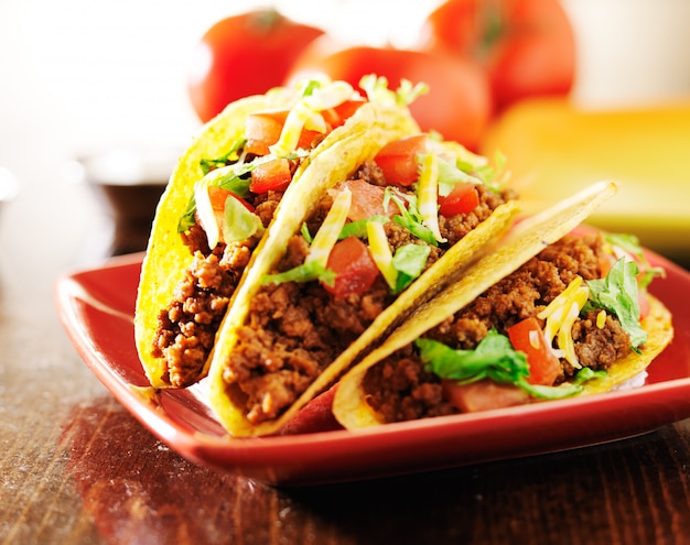 Tres tacos de ternera con queso, lechuga y tomate