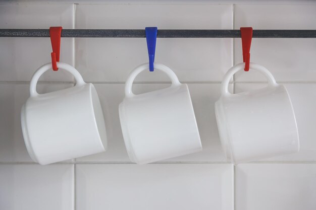 Tres tazas blancas, soporte para platos.