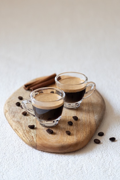 Tres tazas de café, granos de café sobre una tabla de madera, vista superior