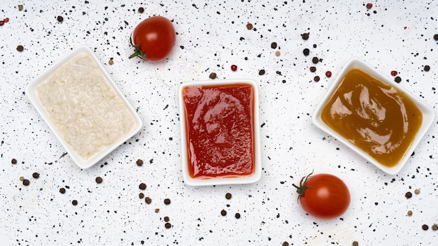 Tres tipos de salsas sobre un fondo de cemento blanco