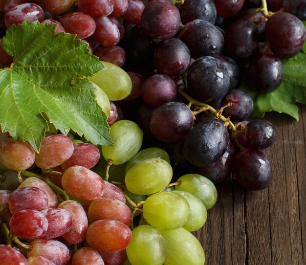 Tres tipos de uvas en una mesa de madera