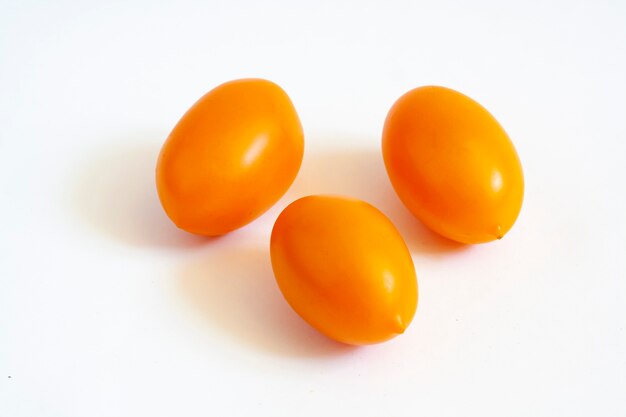 Três tomates amarelos isolados em um fundo branco