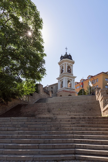 tres tramos de escaleras de piedra torre del campanario de 3 niveles sol de la mañana a través del follaje Plovdiv Bulgaria