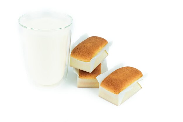 Tres tres magdalenas artesanales hechas a mano con vaso de leche sobre fondo blanco. Panadería de pastelería sobre fondo aislado.