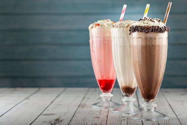 Tres vasos de batido de sabores variados. Batido de chocolate, vainilla y fresa.