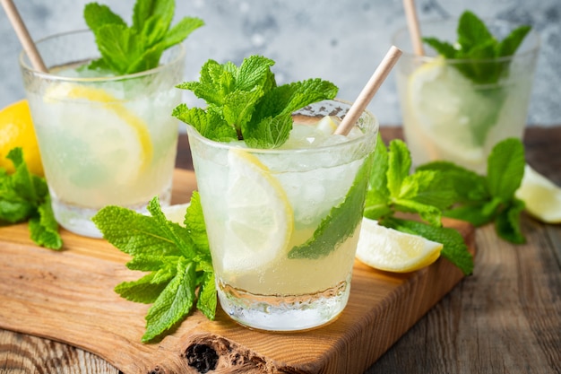 Tres vasos de cóctel mojito en la tabla de cortar de madera