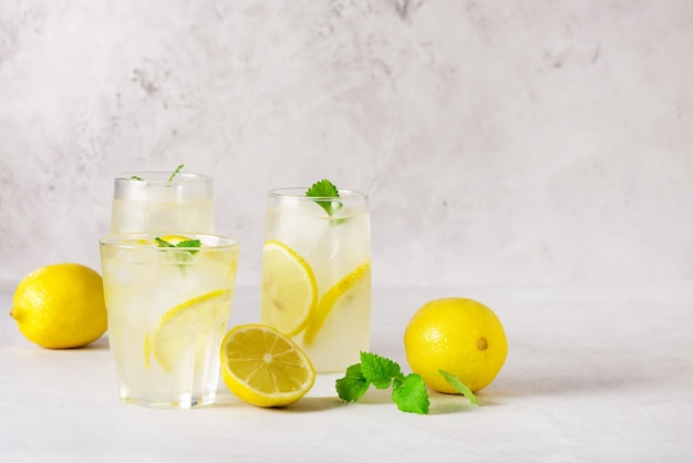 Foto tres vasos con limonada o cóctel con limón y menta bebida o bebida refrescante fría