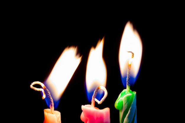 Foto tres velas de cumpleaños sobre fondo negro