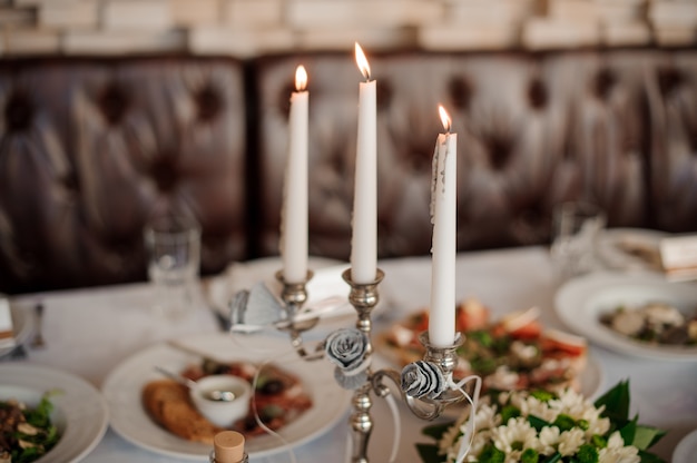 Tres velas en el elegante candelabro que decora una mesa