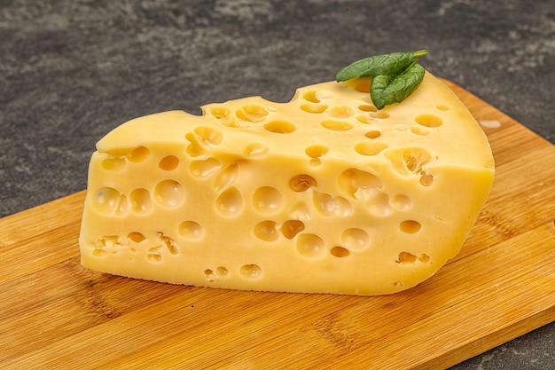 Triángulo amarillo de queso Maasdam con agujeros