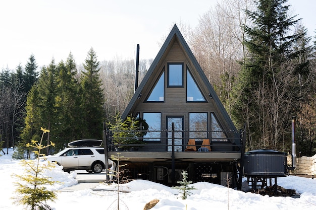 Triângulo de madeira pequena casa de campo com banheira de hidromassagem e carro utilitário com rack de teto nas montanhas Fins de semana da alma