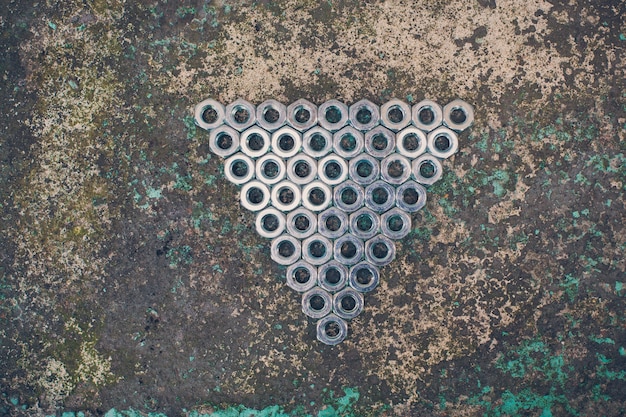 Triângulo de porcas de metal em concreto