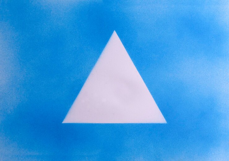 Foto triángulo de pintura en aerosol azul en el papel