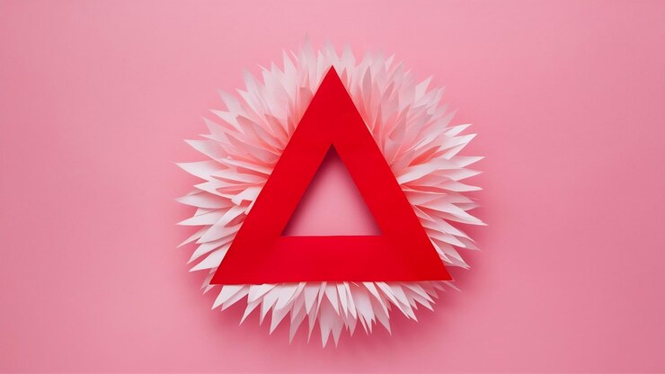Foto triángulo rojo rodeado de fondo de papel rosa