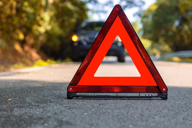 Foto triângulo vermelho, sinal vermelho de parada de emergência, símbolo vermelho de emergência e parada de carro preto e estacionamento na estrada.